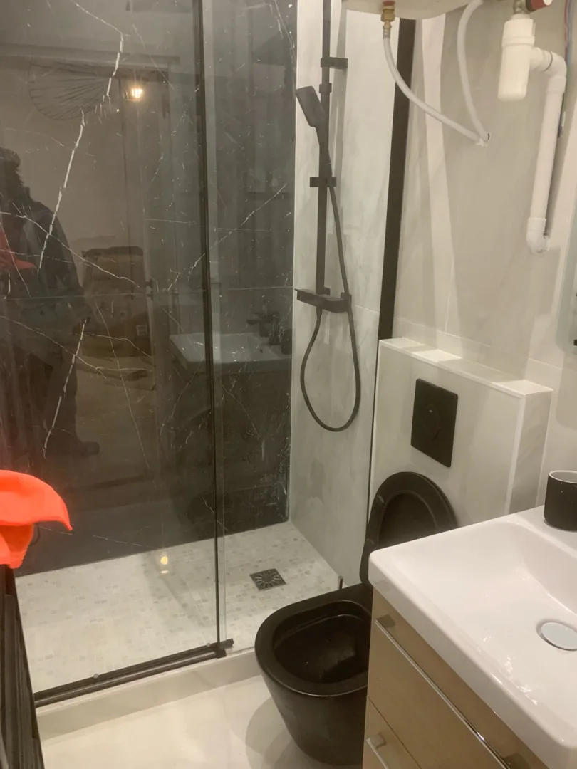 Douche vitrée avec carrelage foncé